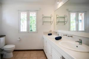 a white bathroom with a sink and a toilet at Beach, Blue Sea, Sunset and Private Pool in Rivière Noire +117 photos