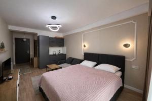 a bedroom with a bed and a living room at Relax Apartments in Crystal Residence Bakuriani in Bakuriani