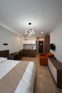 a bedroom with a bed and a living room with a kitchen at Relax Apartments in Crystal Residence Bakuriani in Bakuriani