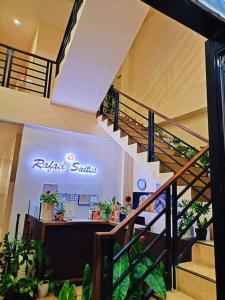 a store with a sign in a building with plants at Rafael Suites Inn in Mojon +2 photos