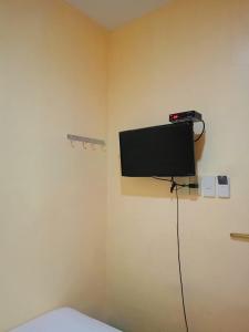 a room with a tv on the wall at Rafael Suites Inn in Mojon