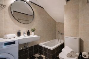 a bathroom with a sink and a toilet and a mirror at Elysium Living in Gouvia