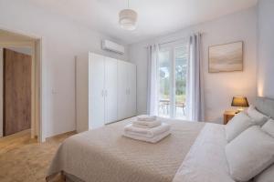 a bedroom with a bed with two towels on it at Elysium Living in Gouvia
