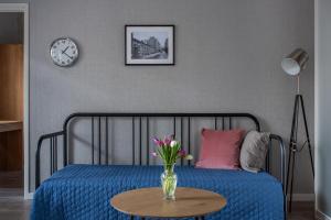 a bedroom with a bed with a vase of flowers on a table at Diana Park Apartments in Helsinki