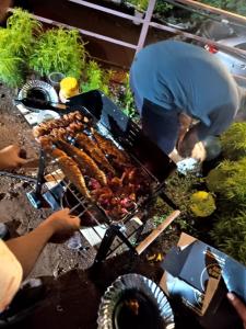 a person is cooking food on a grill at Swara Villa Your Perfect Getaway in Jāmb