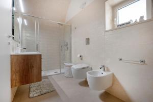 a bathroom with a toilet and a sink and a shower at Ranieri rooms & relax Mare in Mola di Bari
