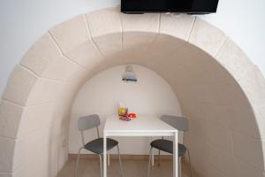 a table and two chairs in a room with an arch at Ranieri rooms & relax Mare in Mola di Bari
