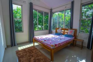a bedroom with a bed in a room with windows at Swara Villa Your Perfect Getaway in Jāmb