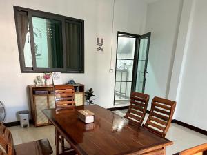 a dining room with a wooden table and chairs at Cocoon Casa in Hat Yai