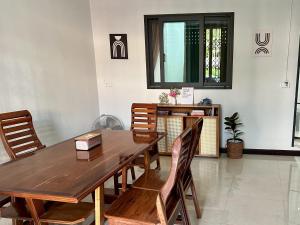 a dining room with a wooden table and chairs at Cocoon Casa in Hat Yai +15 photos