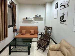 a living room with a couch and a table at Cocoon Casa in Hat Yai