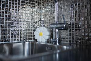 a sink with a flower sitting on top of it at Diana Park Apartments in Helsinki +30 photos