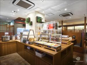a restaurant with a counter with food on it at Daiwa Roynet Hotel Kawasaki in Kawasaki
