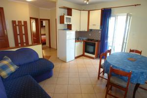 a living room with a blue couch and a table at Apartments Tinka in Povljana