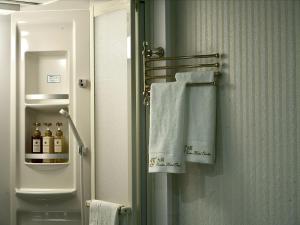 a bathroom with a towel rack with bottles of alcohol at 大同GardenHotel 大阪西九条Annex in Osaka