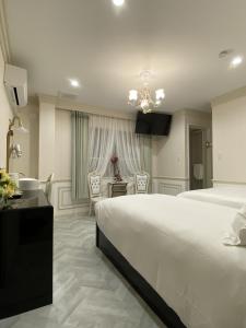 a bedroom with a large white bed and a desk at 大同GardenHotel 大阪西九条Annex in Osaka