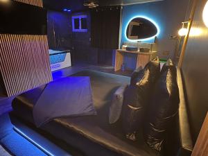 a living room with a couch and a table at Suite Casanova avec SPA & Escape Love Game - Doux Bleu Jeux in Niort
