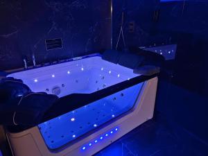 a bath tub with blue lights in a room at Suite Casanova avec SPA & Escape Love Game - Doux Bleu Jeux in Niort