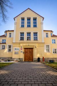 a large yellow building with a brown door at REVIS Tachov in Tachov