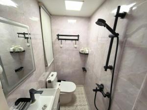 a bathroom with a shower and a toilet and a sink at 木子酒店 in Nanjing