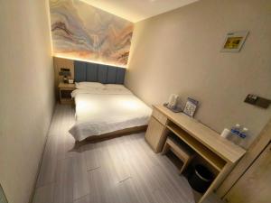 a bedroom with a bed and a painting on the wall at 木子酒店 in Nanjing +1 photo