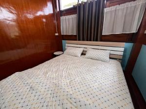 a bedroom with a bed with two pillows on it at Chan Klong No8 Homestay - บ้านชานคลองหมายเลข8 in Sathani Wat Sing