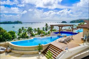 a resort pool with a view of the water at Beautiful Apartment overlooking Samaná Bay in Cayo Vigía