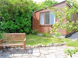 a wooden bench sitting in front of a house at Heather Brae Lodge in Nancledra