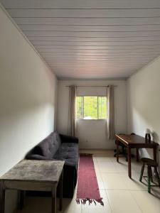 a living room with a couch and a table at Oca Delfim in Delfim Moreira