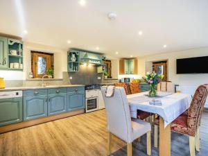 a kitchen with blue cabinets and a table and chairs at Horsecroft - Uk37462 in Dorstone