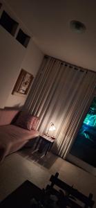 a bedroom with a bed and a window with a lamp at Casa Caminho do Meio in Rio de Janeiro