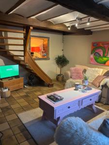 a living room with a coffee table and a staircase at La Petite maison in Montleban