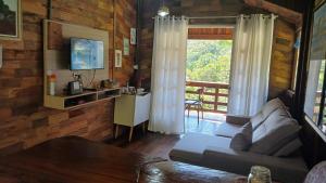 a living room with a couch and a window at Casa de campo rústica 21km vila germânica Bnu in Blumenau