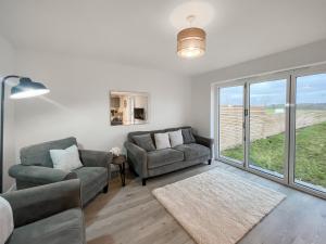 a living room with two couches and a window at Eriska View in Port Appin