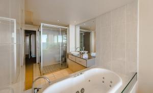 a large bathroom with a tub and a shower at Sandcastle Apartments in Port Macquarie +133 photos