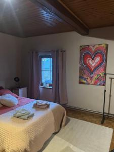 a bedroom with a bed and a painting on the wall at La Petite maison in Montleban
