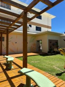 a wooden deck with a pergola in a yard at Residencial Marilis in Palhoça