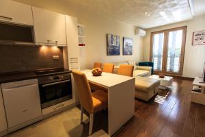 a kitchen with a table and a living room at LuxBeachFront in Petrovac na Moru