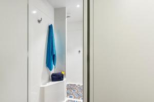 a glass door in a bathroom with a blue umbrella at hotelF1 Aix En Provence Sainte Victoire in Meyreuil +44 photos