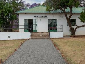 a white building with a tree in front of it at Zebra Nature Reserve in Cullinan +31 photos