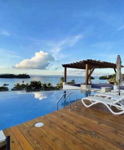 a villa with a infinity pool and a wooden deck at Beautiful Apartment overlooking Samaná Bay in Cayo Vigía