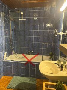 a blue tiled bathroom with a sink and a tub at La Petite maison in Montleban +37 photos