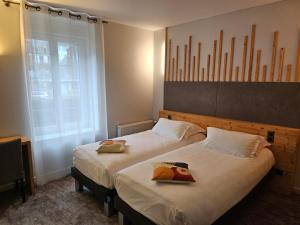 a bedroom with two beds and a window at Le Castelet Sancy - Jardin & Spa in Le Mont-Dore +53 photos