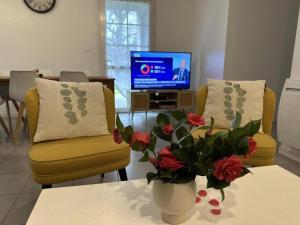 a living room with two chairs and a vase with flowers at L'etable in Orx