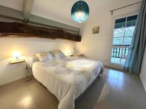 a bedroom with a large bed and a large window at L'etable in Orx