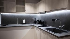 a kitchen with white cabinets and a sink at Komody Apartments in Delphi +151 photos