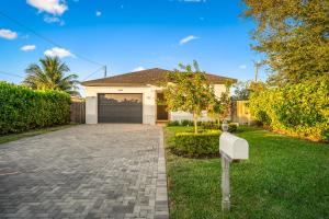 a house with a driveway and a garage at Delray Oasis - Private Pool - Fenced Yard - Parking - Laundry - Full Kitchen - Convenient Location in Delray Beach