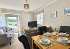 a living room with a table and chairs and a television at Sunset Cottage in Llanddulas