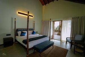 a bedroom with a bed with a cross on it at Seascape Beach Retreat in Kannur
