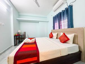 a bedroom with a large bed with red pillows at Redfox Service Apartment - Ambattur in Jāmb